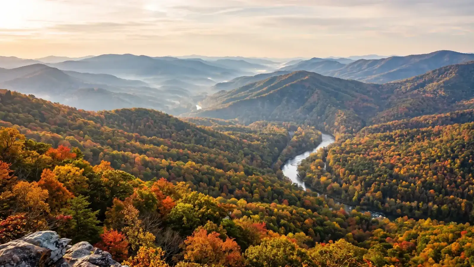 A sweeping view of layered Blue Ridge mountains and a winding river valley in North Georgia
